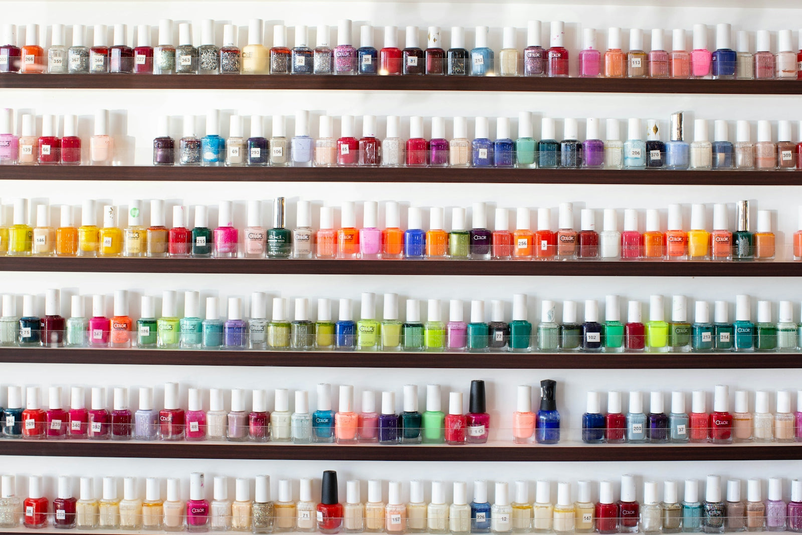 white and pink plastic bottles on white shelf