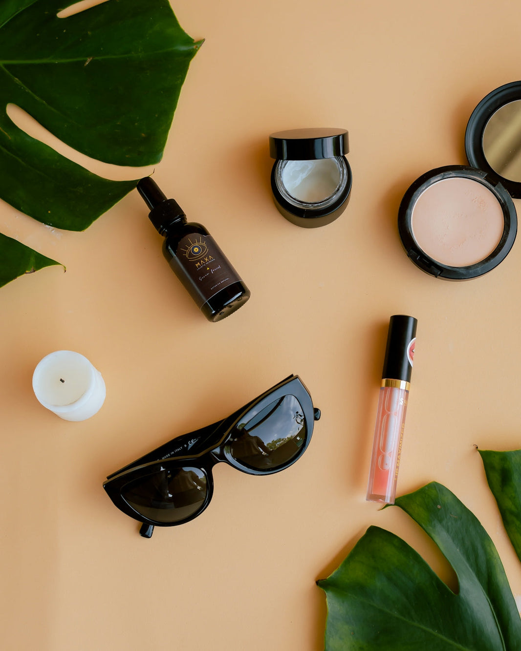 black framed sunglasses beside pink and green lipstick