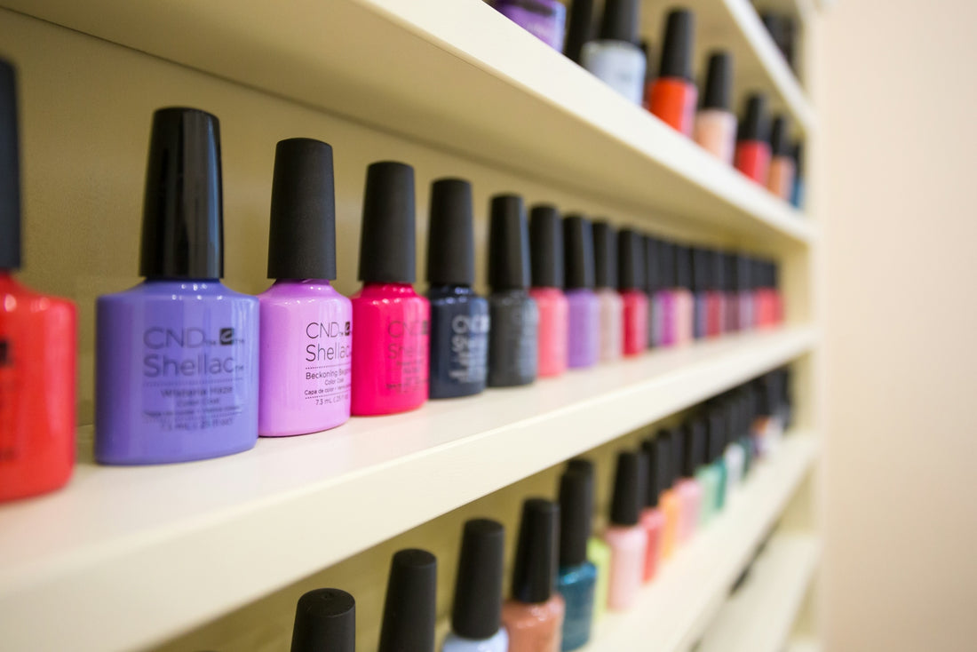 purple nail polish bottle on white wooden shelf