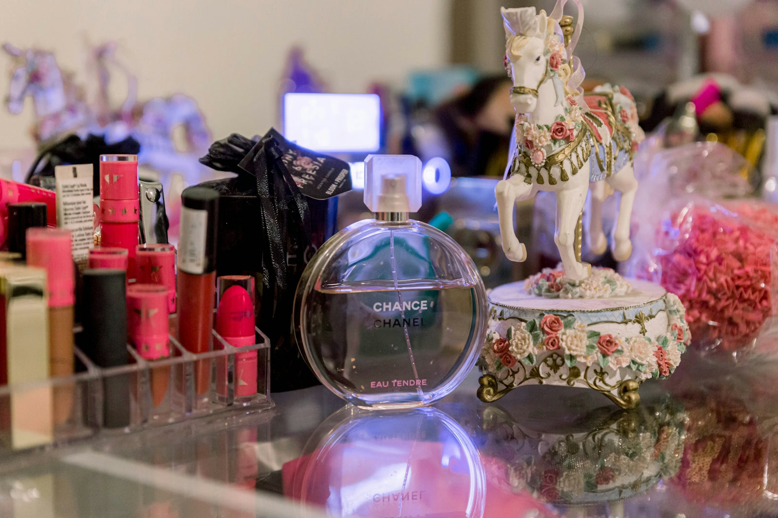 a glass table topped with lots of bottles of perfume