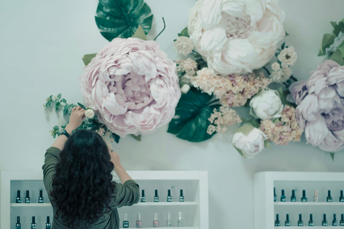 a woman is arranging flowers on a wall