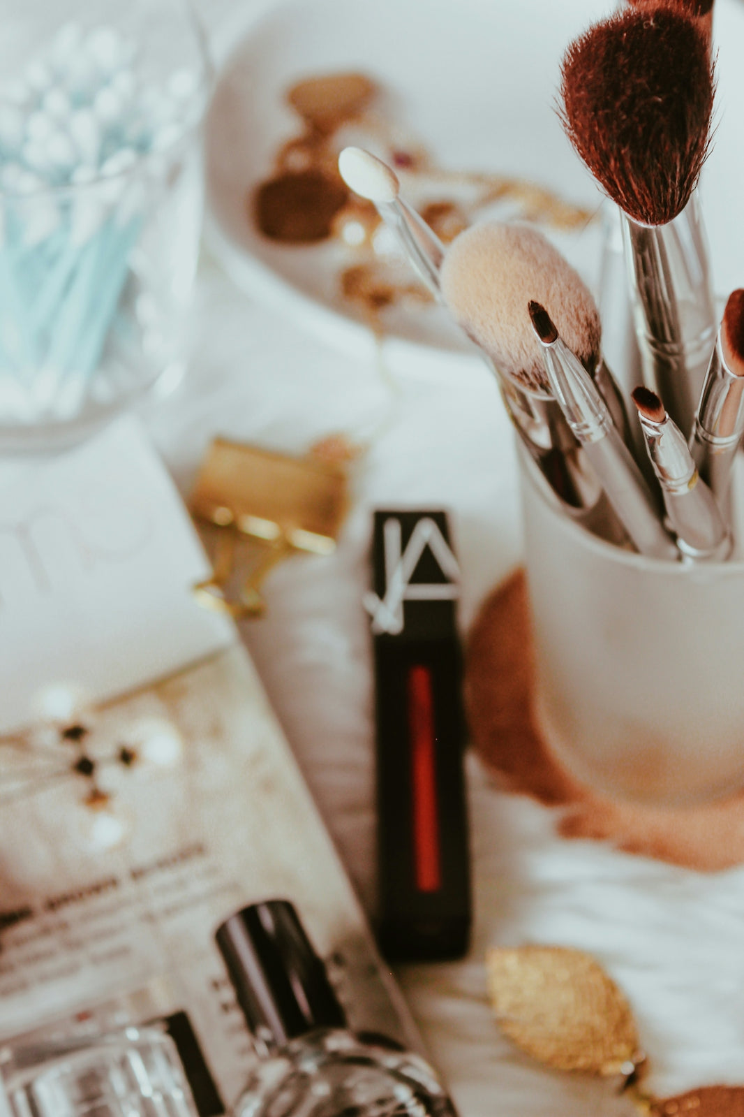 a close up of makeup brushes in a cup