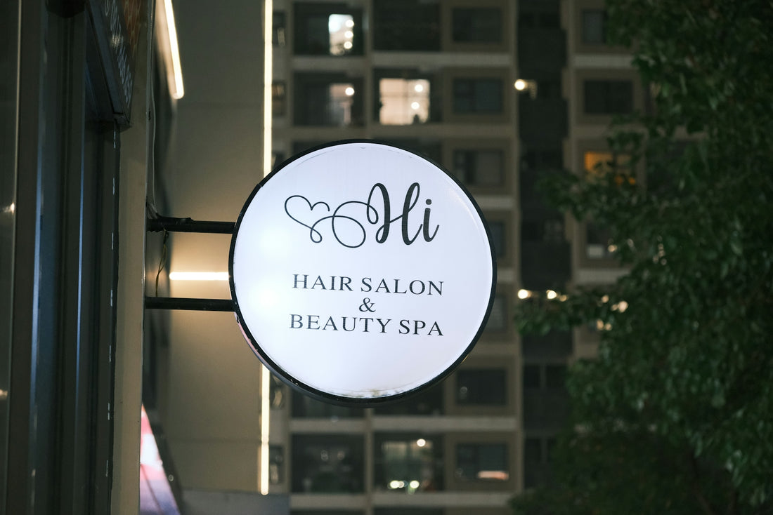 a salon sign hanging from the side of a building