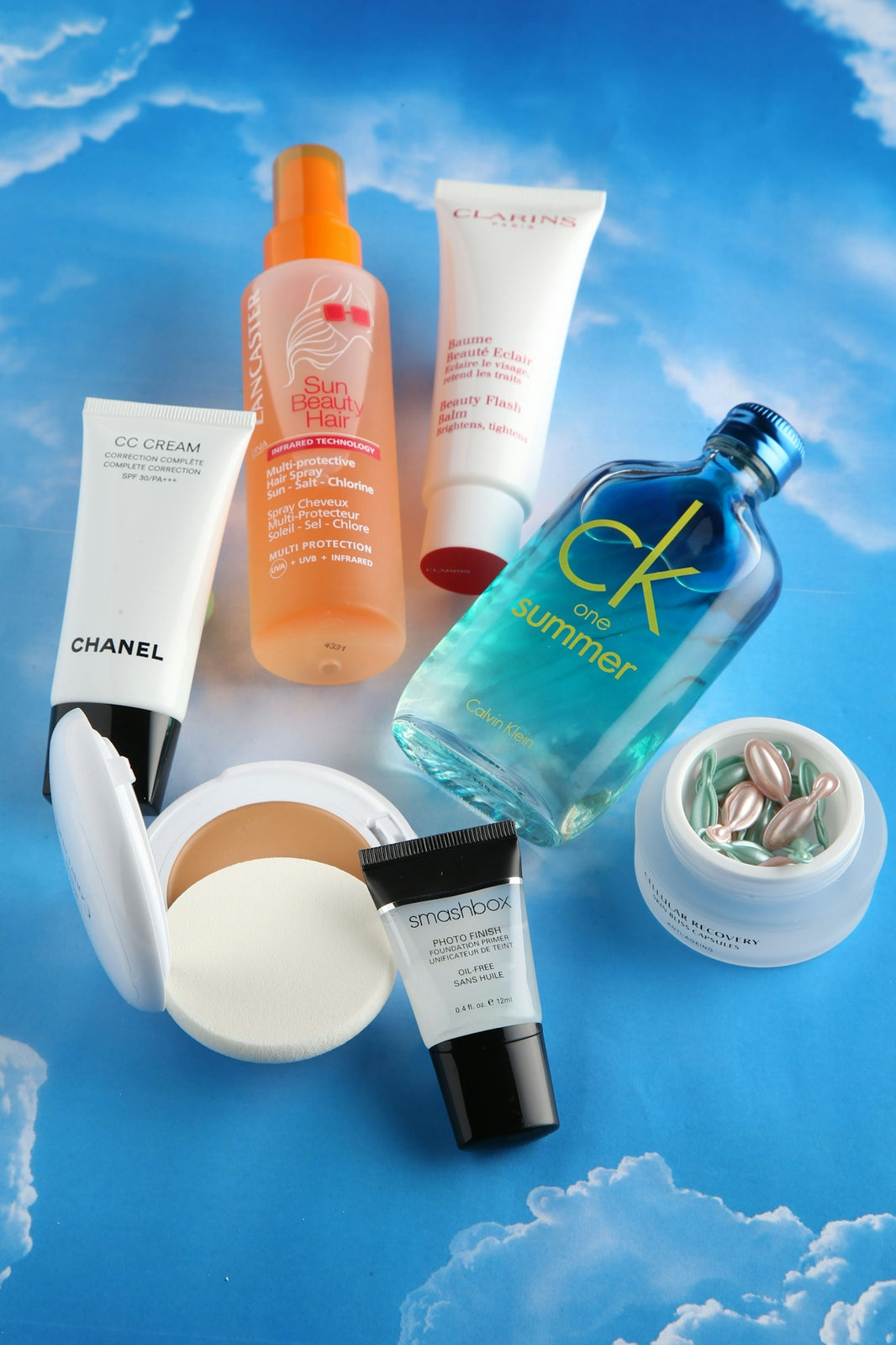 Cosmetics and beauty products are arranged on a blue background.