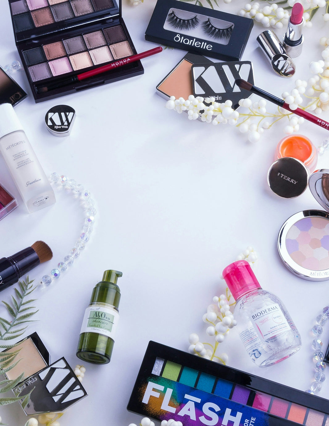 Makeup products and accessories are arranged on a white surface.