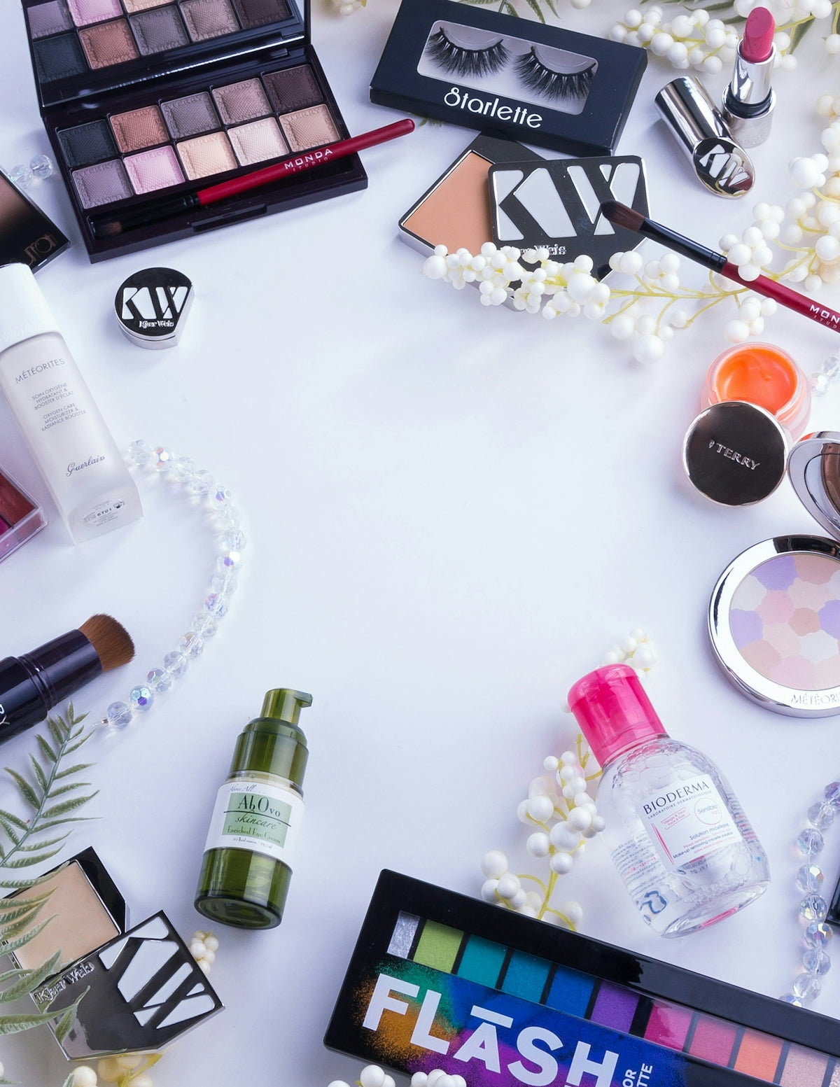 Makeup products and accessories are arranged on a white surface.
